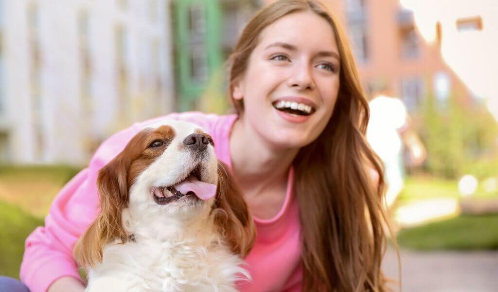cavalier king charles spaniel and a woman next to each other